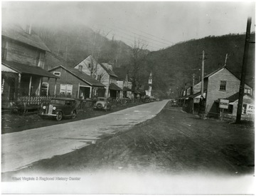 Houses in a coal town with a few cars parked along the street.