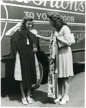 Two women check out dresses for sale.