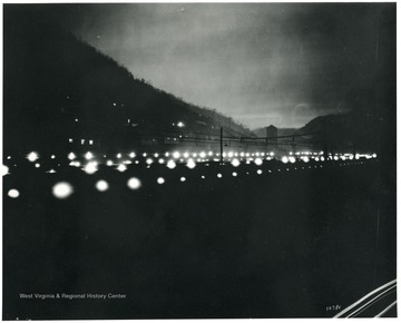 A dark picture of coke ovens lit up at night.