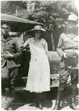 Two troopers with a lady in a dress between them. 'All days aren't dark days to the State Troopers in Mingo.'