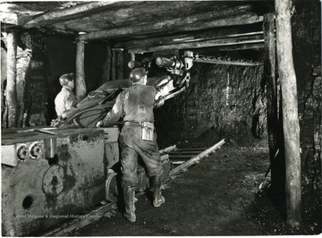 Two miners operate a cutting machine. 'Credit must be given to Willaim Vandivert, 21 East Tenth St., New York 3, N.Y., Not to be reproduced without written liscense.'