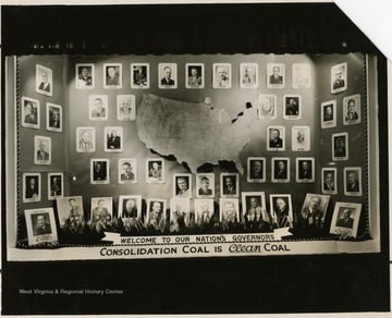 'Background: Back and side walls are covered with flag blue no seam matting edged with red, white and blue braided silk. Floor is covered with red crystalline cloth and draped over a partial platform in the rear of the window. Display: In the center of the back wall is a map of the United States raised a bit from the wall to make it stand out. All around this map are photographs of 50 Governors, 47 from the States and 3 from the Territories and under these photos are the names and states of all the Governors. Some are place on the platform on the floor in the back with the Chairman of the Conference at one end and the Host at the other. A welcome banner is placed in front behind which is a stand containing a small state flag for each of the 48 states and 4 territories. Remarks: This window is our best so far I believe, from the standpoint of attracting attention and being talked about. The coloring at night is particularly attractive with the two spot lights bringing out the colors quite vividly. We have had many residents call in and stop in to remark on the window and there have been as many as 25 people at one time looking at it out front. It has proven timely for two events, the Governors Conference and the Republican Convention in Philadelphia this week. The majority of the Governors as well as their parties also stopped by to see our display.'