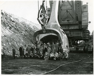 Group of men standing in front of a large shovel, probably the Tiger.