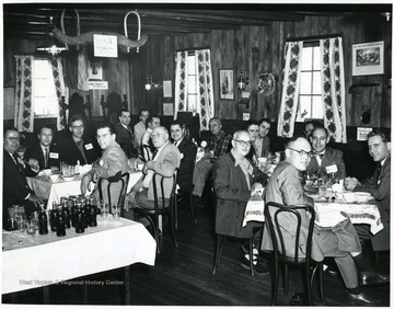 Men take a break from their meals to smile for the camera.