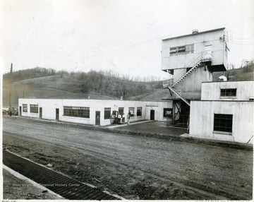 Four people stand outside the doorway to a portion of the Jamison Preparation Plant.