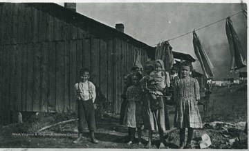 Children are standing under the clothes line.