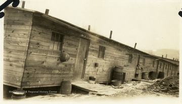 Barracks at Columbia, W. Va. with little girl standing in doorway.