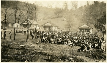 Group portrait of church members in yard in front of some houses.