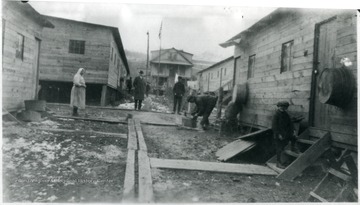 Small boy on steps smiling with a man in the background working.