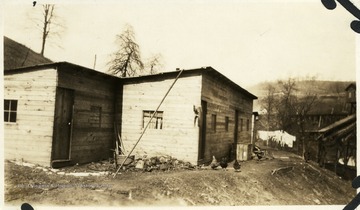 Chickens in front of barracks at Pitcairn with laundry hanging in the background.