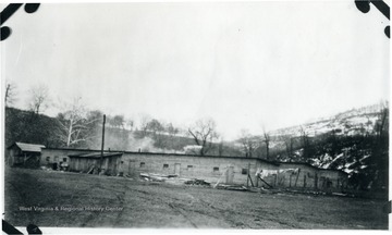 Piles of lumber stacked beside the barracks at Wyatt, W. Va.