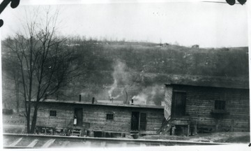 Man standing in doorway of barracks.