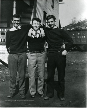 Picture of three men standing in front of a building.