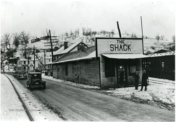 Two unidentified men standing in front of the Shack building on a winter day.