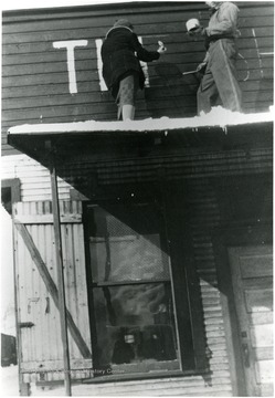 Mary Behner(later Christopher)and George Lay painting the name on the building's facade.