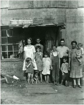 Unidentified family with their pet in front of a house in Scott's Run, W. Va.