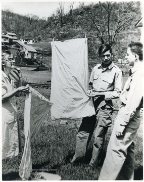 Two men and a lady hanging clothes to dry in Marion County, W. Va. 'For information on the Mountaineer Mining Mission, See A&amp;M 2491 (S.C.).'