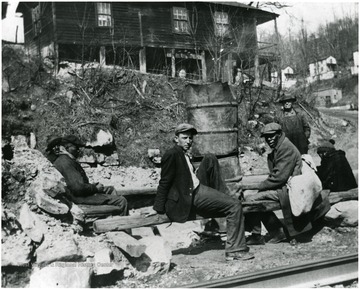 Men sitting on logs during the 1931 coal strike at Scott's Run, W. Va.