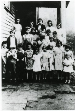 Group portrait of students standing on steps outside of school.