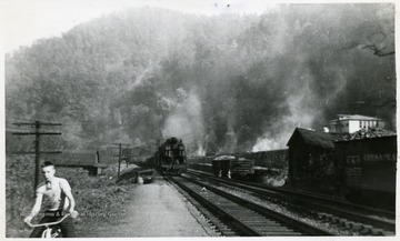 Coke ovens, tipple and white school house shown. Jr. Barker is on the bike.