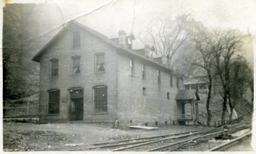 There is a house in the background behind the store. 'Charlie Smith'