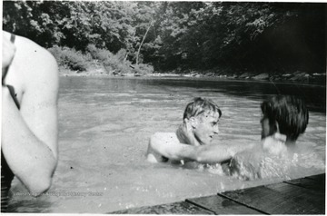 Two men play in water, possibly American Friends Service Committee Workers.