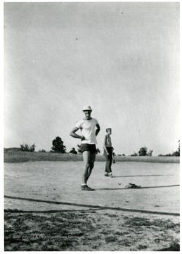 Two men stand in a open field.