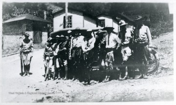 Mingo militiamen stand for portrait next to a car.