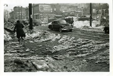 A person is walking on the sidewalk of Jackson and Monroe Street in Fairmont, West Virginia during the big snow storm of 1950.