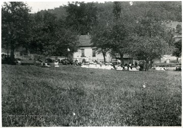 People sit on the ground outside of the Helvetia Church.