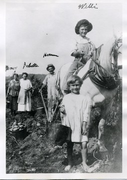 Willie, Herman, Babette, and Merry Schneider are working in the garden.