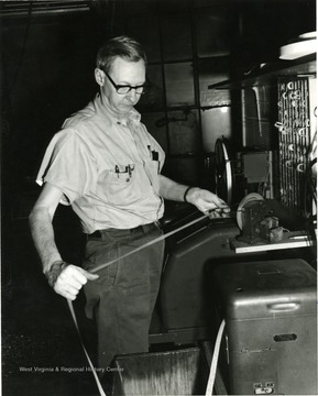 Man reading some tape. 'For Centennial.'