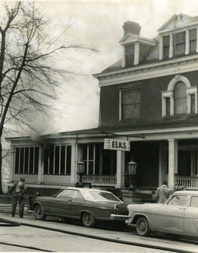 Smoke seen escaping window of the Elks Club in Morgantown, W. Va. Firefighter seen with equipment ready. 