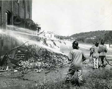 Firefighters seen extinguishing a fire at Moore Electric in Sabraton, near Morgantown, W. Va. Debris seen on steps and in front of building. 