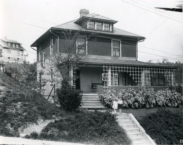Front view of the residence of H. B. Allen in Morgantown, W. Va. Two children stand in front of the house on the walk way above the steps. Another house can be seen behind this residence. 