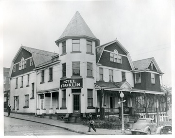 A young boy is walking in front of the Hotel Franklin in Morgantown, West Virginia.