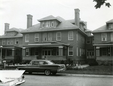 Exterior view of Sundale Rest Home in Morgantown, West Virginia. Flowers seen near walk way infront of building. 