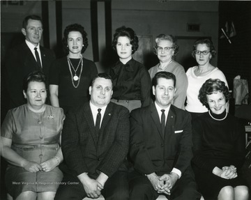 'Monday- V. F. W. will conduct drive- Mr. Ed Kimble is president of Monongalia County chapter and appointed V.F.W. to conduct drive.: Front row: left to right: Maxine Courtney, mother's march chairman; William Robinson, co-chairman of V. F. W. drive; Harry Howell, chairman V.F.W. drive, and Virginia Graham, County Chairman of Mother's March. Standing: Jack Courtney, dance chairman; Helen Robinson, co-chairman of dance, Paulette Felton, teen-age chairman; Lula Cole, Mother's March treasurer, and Carmilla Zuccari, mail chairman. Not pictured: Ed Kimble president of Monongalia County Chapter and Treasurer of drive and Steve Edwards, University Collection Chairman.'