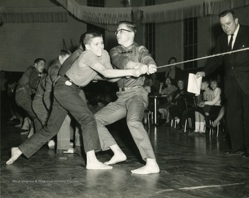 Boy scouts in Morgantown, West Virginia in a competition of tug of war. Man concentrating on competition. 