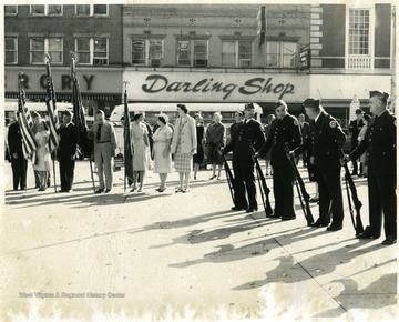 Men in uniform holding guns and flags.