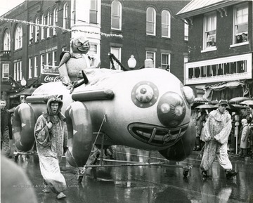 Two people pull a float in the parade. 