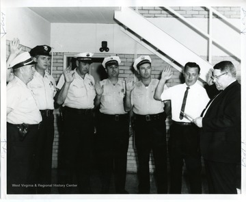 City Policemen taking oath. (right to left): James Ashburn, Robert West, George Ratchur, Bennie Palmer, Bill Hughes, William Musgrave, and Chief John Lewis.