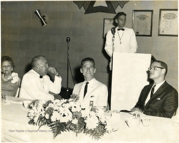 Speaker at the podium behind the table.