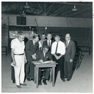 Jennings Randolph standing next to man at table.