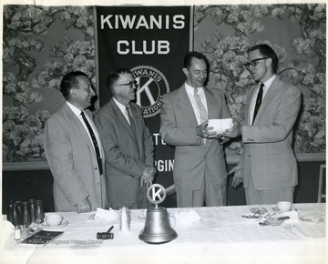 'Gasorama Chairman Kenneth Kincaid 'far right' presenting Gasorama tickets to, left to right, Ward Stone, Collins Veach, and Bob Yagley for the Kiwanis Club's annual Gasorama to be held at a local gas station on Tuesday June 17th.  All club members were presented with tickets which will be sold to the public to help finance the Kiwanis youth program.  The ticket purchaser will obtain gas at the regular station price by cashing in his tickets for the above day.  The service station manager is donating his profit for that day.'