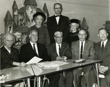 Group of older men and women in front of a Christmas display.
