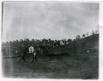 Four young men are playing baseball in Morgantown, West Virginia.