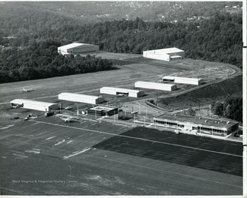 An aerial view of the Morgantown Municipal Airport in Morgantown, West Virginia. Icludes a 5200' x 150' runaway, taxiway, ramp, terminal building, FAA Flight Service Station, T-Hanger, city hanger, and West Virginia University hangar.