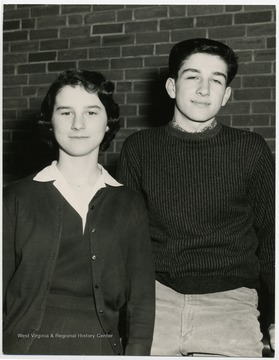 David DeCarlo and unknown girl posed by brick wall at St. Francis in Morgantown W. Va.