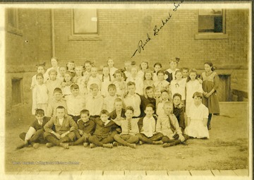 Class portrait of children outside of Seneca Elementary School.  Identified in the back row is Ruth Lenhart Smith.